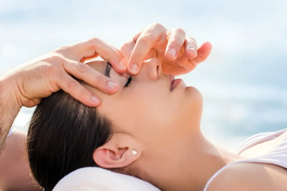 Osteopath doing facial therapy on woman